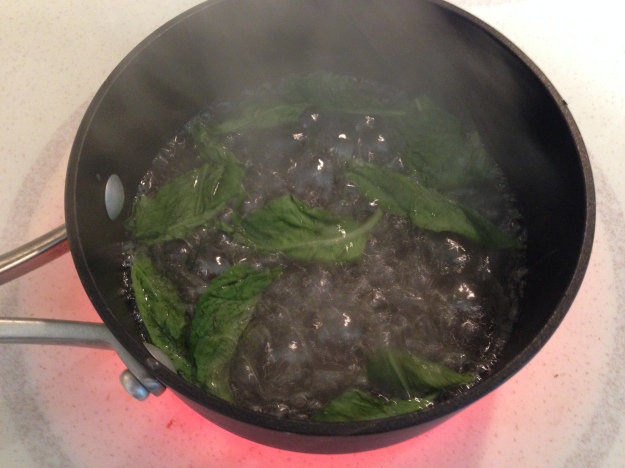 Basil infusing into the simple syrup before being taken off the stove.